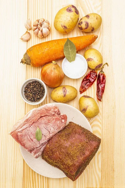 Ingredients for meat stew with potatoes and vegetables. Raw pork fillet, brisket, spices on a stone background, top view. — Stock Photo, Image