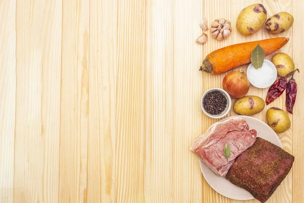 Hozzávalók húspörkölt burgonyával és zöldségekkel. Nyers sertésfilé, marhaszegy, fűszerek kő alapon, felülnézet, másolás hely. — Stock Fotó