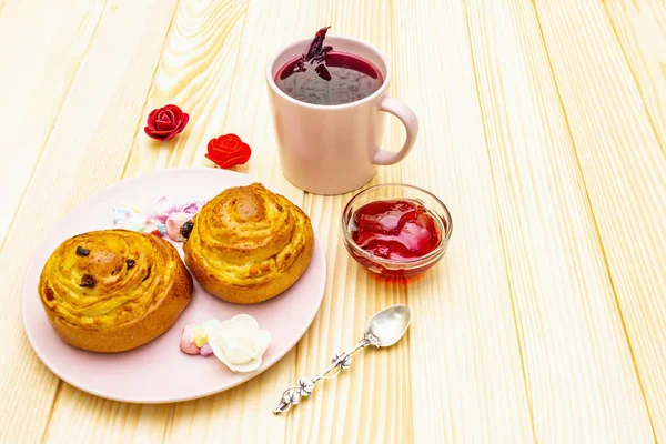 Karkade tea from hibiscus petals (Sudanese rose). Gentle romantic breakfast concept. Buns, meringues, strawberry jelly. On a wooden background, copy space. — Stock Photo, Image