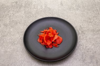 Turşulu sushi zencefil dilimleri taştan arka planda siyah tabakta, üst manzara