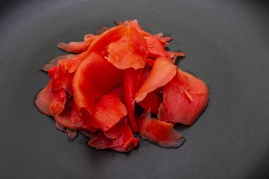 Turşulu sushi zencefil dilimleri taştan arka planda siyah tabakta, yakın plan, makro.