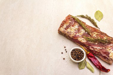 Çiğ domuz filetosu, türler ve bitkiler. Taş zemin üzerinde büyük bir parça salamura et (marine edilmiş), üst görünüm