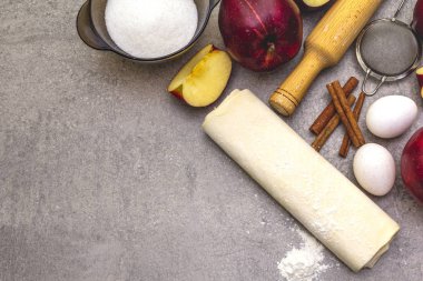 Elmalı turta malzemeleri pişirme konsepti. Tarçınlı taze elmalar, un, şeker, yumurta. Taş zemin üzerinde aşçılık süreci, üst görünüm, kopyalama alanı