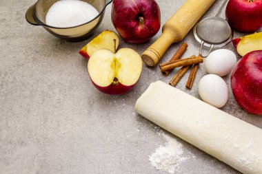 Elmalı turta malzemeleri pişirme konsepti. Tarçınlı taze elmalar, un, şeker, yumurta. Taş zemin üzerinde pişirme işlemi