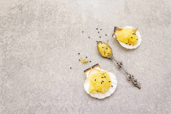 Capelin roe w muszelkach. Czarne nasiona sezamu z płatkami bonito. Lekko solona kawior przekąska w srebrnej łyżeczce na kamiennym tle — Zdjęcie stockowe