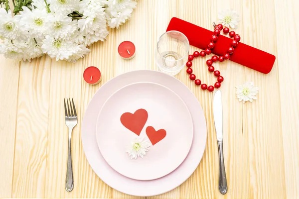 Ρομαντικό δείπνο. Ημέρα του Αγίου Βαλεντίνου, 8η Μαρτίου ή γάμος. Ρύθμιση τραπεζιού, καρδιές αγάπης, δώρο και λουλούδια. Σε ξύλινο φόντο, πάνω όψη — Φωτογραφία Αρχείου