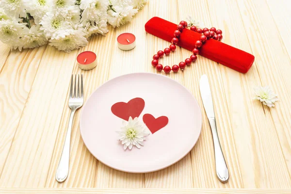Romantikus vacsora koncepció. Valentin nap, március 8., esküvő. Asztaldíszítés, szerelmi szívek, ajándék és virágok. Fa alapon — Stock Fotó