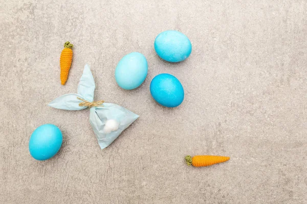 Пасхальный кролик (кролик) бумажный подарочный яйцо упаковки с вязаной морковкой идея. Ремесленная (самодельная) концепция для детей (детей). На каменном фоне, вид сверху — стоковое фото