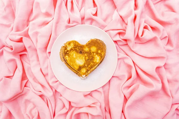 Heart shaped pancakes for romantic breakfast on rosy plate. Shrovetide (carnival) concept. On pink cloth linen background, top view — Stock Photo, Image