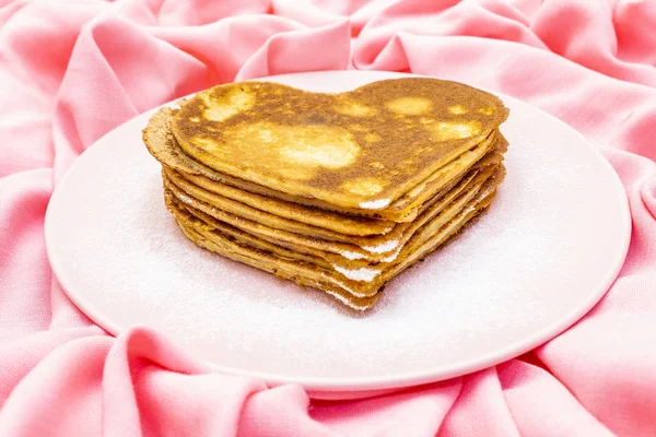 Crêpes en forme de coeur pour le petit déjeuner romantique sur assiette rose. Concept de Shrovetide (carnaval). Sur fond lin tissu rose — Photo