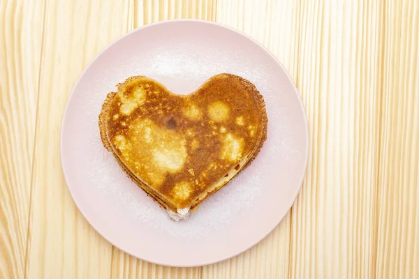 Crêpes en forme de coeur pour le petit déjeuner romantique. Concept de Shrovetide (carnaval). Sur fond bois, vue de dessus — Photo