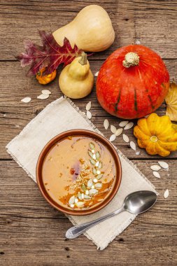 Sonbahar balkabağı kremalı çorbası. Geleneksel malzemeler, sağlıklı gıda konsepti. Peçete, eski ahşap arka plan