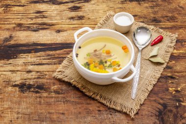 Şeffaf ördek çorbası ve sebze kasesi. Geleneksel bulyon, sağlıklı yemek. Eski tahta arkaplan