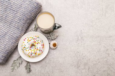 Çörekle birlikte sıcak kahve. Süveter, yapraklar ve çiçeklerle iyi bir ruh hali için kış içkisi. Eski tahta arka plan