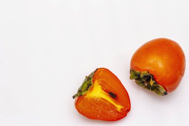 Olgunlaşmış tek bir hurma. Taze meyve, yarısı dilimlenmiş. Beyaz arkaplanda izole