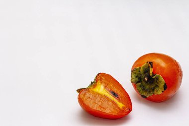 Olgunlaşmış tek bir hurma. Taze meyve, yarısı dilimlenmiş. Beyaz arkaplanda izole