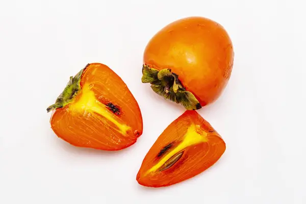 Matura cachi singoli. Frutta intera fresca, tagliata a metà, semi. Isolato su sfondo bianco — Foto Stock
