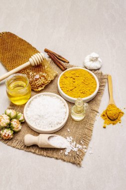 Doğal malzemelerle kişisel bakım. Sağlıklı spa konsepti. Zerdeçal, deniz tuzu, bal, tarçın, yağ. Taş beton arka plan