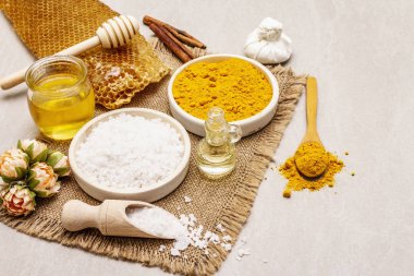 Doğal malzemelerle kişisel bakım. Sağlıklı spa konsepti. Zerdeçal, deniz tuzu, bal, tarçın, yağ. Taş beton arka plan