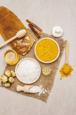 Doğal malzemelerle kişisel bakım. Sağlıklı spa konsepti. Zerdeçal, deniz tuzu, bal, tarçın, yağ. Taş beton arka plan