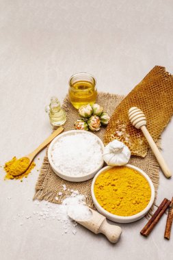 Doğal malzemelerle kişisel bakım. Sağlıklı spa konsepti. Zerdeçal, deniz tuzu, bal, tarçın, yağ. Taş beton arka plan