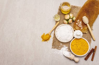 Doğal malzemelerle kişisel bakım. Sağlıklı spa konsepti. Zerdeçal, deniz tuzu, bal, tarçın, yağ. Taş beton arka plan