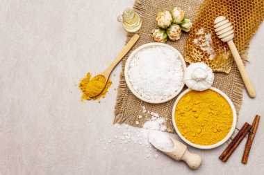 Doğal malzemelerle kişisel bakım. Sağlıklı spa konsepti. Zerdeçal, deniz tuzu, bal, tarçın, yağ. Taş beton arka plan