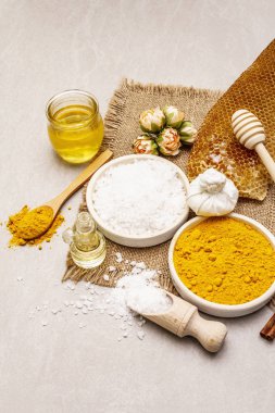Doğal malzemelerle kişisel bakım. Sağlıklı spa konsepti. Zerdeçal, deniz tuzu, bal, tarçın, yağ. Taş beton arka plan