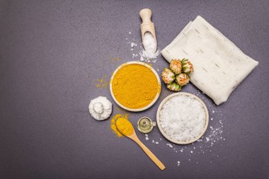 Doğal malzemelerle kişisel bakım. Sağlıklı spa konsepti. Zerdeçal, deniz tuzu, yağ, havlu. Taş beton arka plan