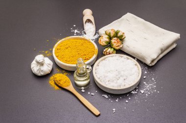 Doğal malzemelerle kişisel bakım. Sağlıklı spa konsepti. Zerdeçal, deniz tuzu, yağ, havlu. Taş beton arka plan