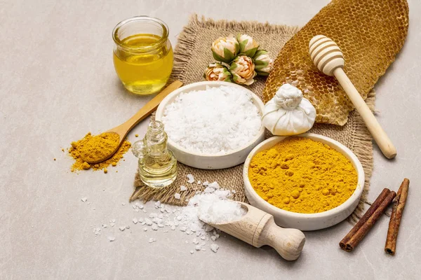 Doğal malzemelerle kişisel bakım. Sağlıklı spa konsepti. Zerdeçal, deniz tuzu, bal, tarçın, yağ. Taş beton arka plan