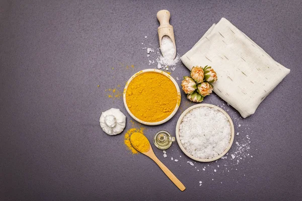 Doğal malzemelerle kişisel bakım. Sağlıklı spa konsepti. Zerdeçal, deniz tuzu, yağ, havlu. Taş beton arka plan