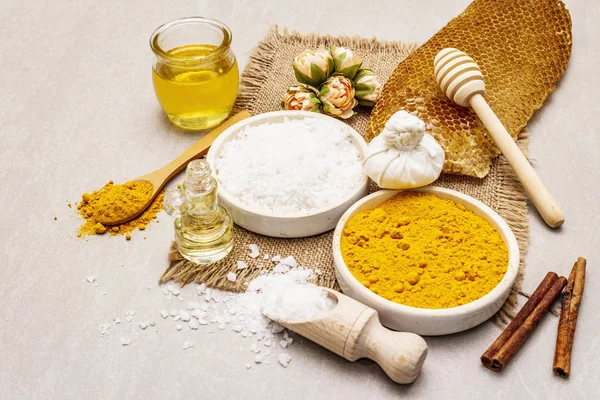 Cuidado personal con ingredientes naturales. Concepto de spa saludable. Cúrcuma, sal marina, miel, canela, aceite. Fondo de hormigón piedra — Foto de Stock