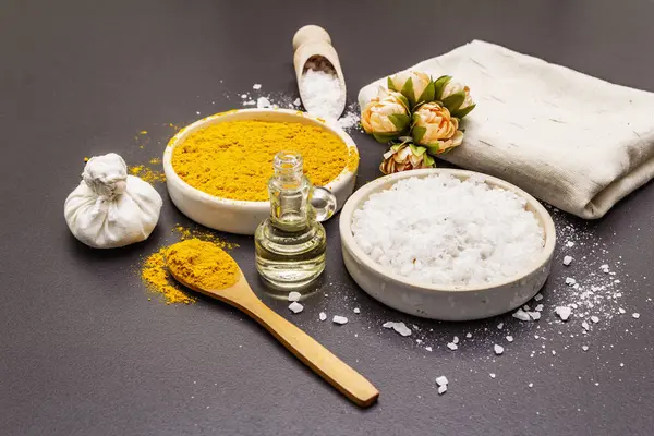 Cuidado personal con ingredientes naturales. Concepto de spa saludable. Cúrcuma, sal marina, aceite, toalla. Fondo de hormigón piedra — Foto de Stock