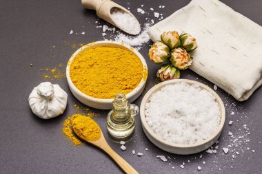 Doğal malzemelerle kişisel bakım. Sağlıklı spa konsepti. Zerdeçal, deniz tuzu, yağ, havlu. Taş beton arka plan