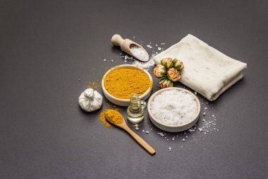 Doğal malzemelerle kişisel bakım. Sağlıklı spa konsepti. Zerdeçal, deniz tuzu, yağ, havlu. Taş beton arka plan