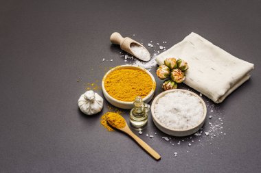 Doğal malzemelerle kişisel bakım. Sağlıklı spa konsepti. Zerdeçal, deniz tuzu, yağ, havlu. Taş beton arka plan