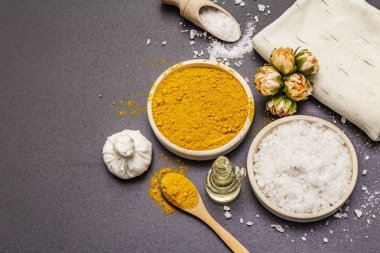 Doğal malzemelerle kişisel bakım. Sağlıklı spa konsepti. Zerdeçal, deniz tuzu, yağ, havlu. Taş beton arka plan