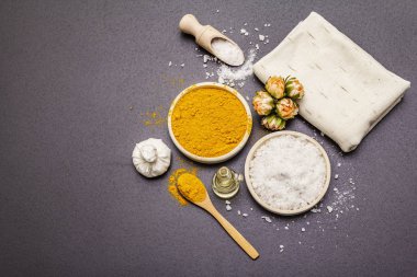 Doğal malzemelerle kişisel bakım. Sağlıklı spa konsepti. Zerdeçal, deniz tuzu, yağ, havlu. Taş beton arka plan