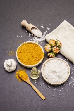 Doğal malzemelerle kişisel bakım. Sağlıklı spa konsepti. Zerdeçal, deniz tuzu, yağ, havlu. Taş beton arka plan