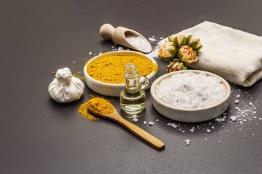 Doğal malzemelerle kişisel bakım. Sağlıklı spa konsepti. Zerdeçal, deniz tuzu, yağ, havlu. Taş beton arka plan