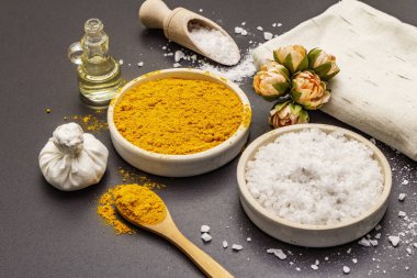 Doğal malzemelerle kişisel bakım. Sağlıklı spa konsepti. Zerdeçal, deniz tuzu, yağ, havlu. Taş beton arka plan