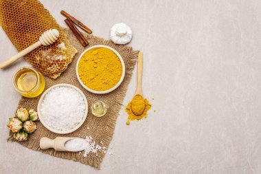 Doğal malzemelerle kişisel bakım. Sağlıklı spa konsepti. Zerdeçal, deniz tuzu, bal, tarçın, yağ. Taş beton arka plan