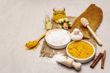 Doğal malzemelerle kişisel bakım. Sağlıklı spa konsepti. Zerdeçal, deniz tuzu, bal, tarçın, yağ. Taş beton arka plan