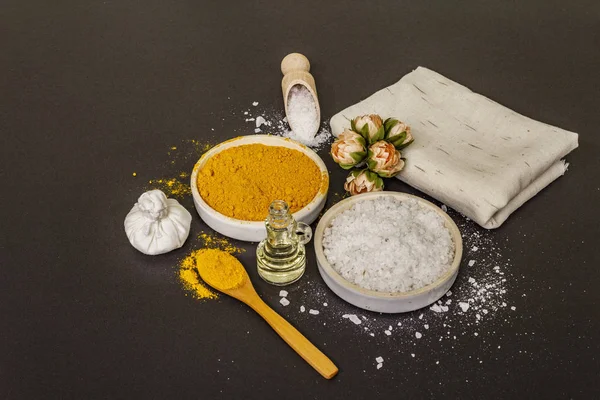 Personal care with natural ingredients. Healthy spa concept. Turmeric, sea salt, oil, towel. Stone concrete background