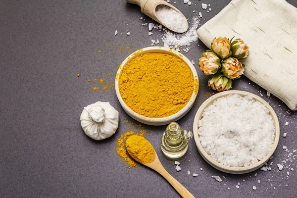 Doğal malzemelerle kişisel bakım. Sağlıklı spa konsepti. Zerdeçal, deniz tuzu, yağ, havlu. Taş beton arka plan