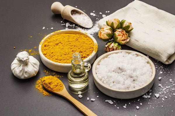 Cuidado personal con ingredientes naturales. Concepto de spa saludable. Cúrcuma, sal marina, aceite, toalla. Fondo de hormigón piedra — Foto de Stock