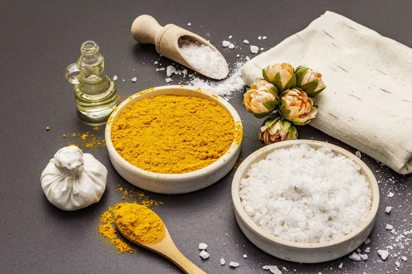 Cuidado personal con ingredientes naturales. Concepto de spa saludable. Cúrcuma, sal marina, aceite, toalla. Fondo de hormigón piedra — Foto de Stock