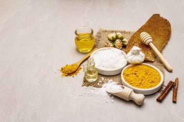 Doğal malzemelerle kişisel bakım. Sağlıklı spa konsepti. Zerdeçal, deniz tuzu, bal, tarçın, yağ. Taş beton arka plan