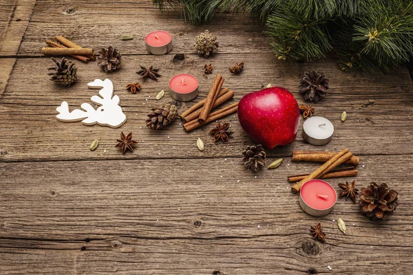 Spirit Christmas background. New Year tree, apple, candles, spices, deer, cones. Nature decorations, vintage wooden boards